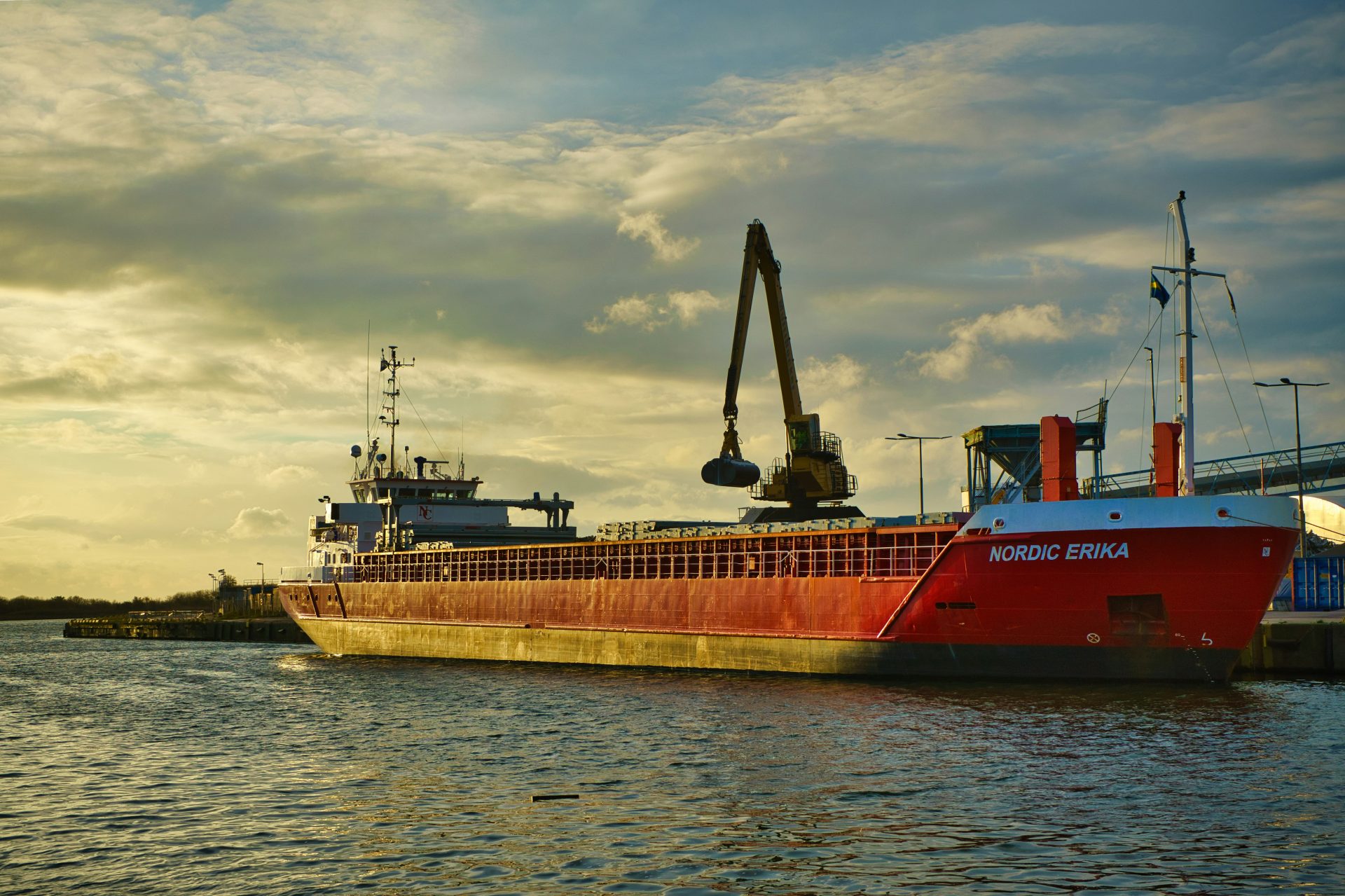un grand bateau rouge flottant sur un plan d'eau