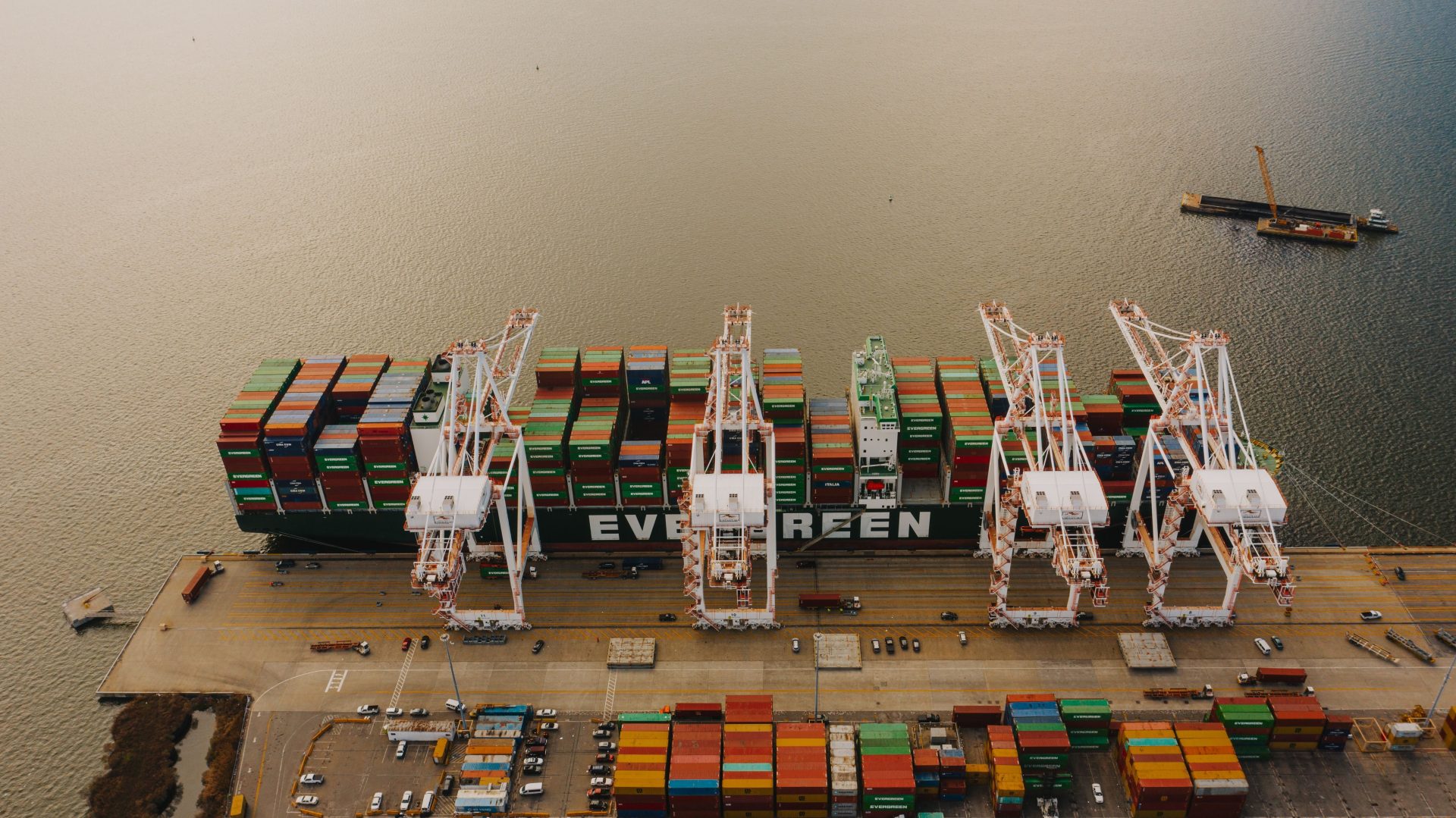From above of many cargo containers on ship moored on calm water of river in daytime